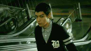 a man is walking down an escalator in a dark room .