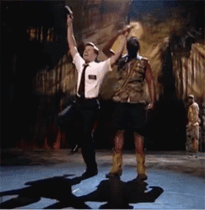 a man in a white shirt and tie is dancing with a man in a kilt