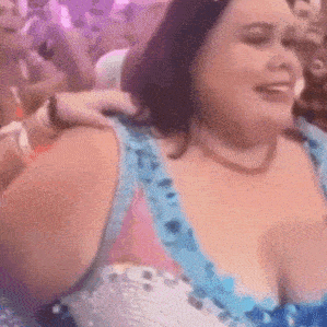 a woman in a blue and white dress is dancing in a crowd at a party .