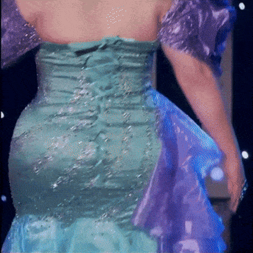 a woman in a blue and purple dress is standing