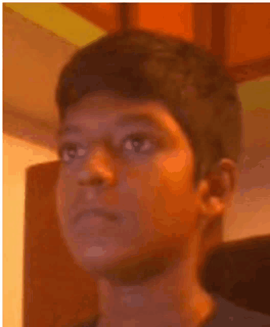 a close up of a young man 's face with a blurred background