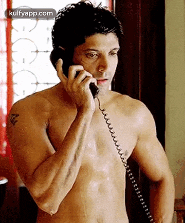 a shirtless man is talking on a telephone without a shirt on .