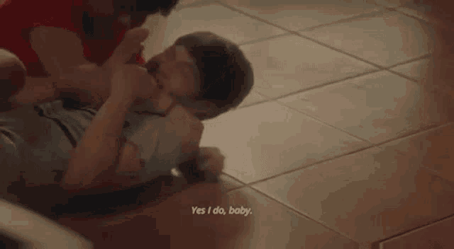 a man and a woman are laying on the floor and fighting .