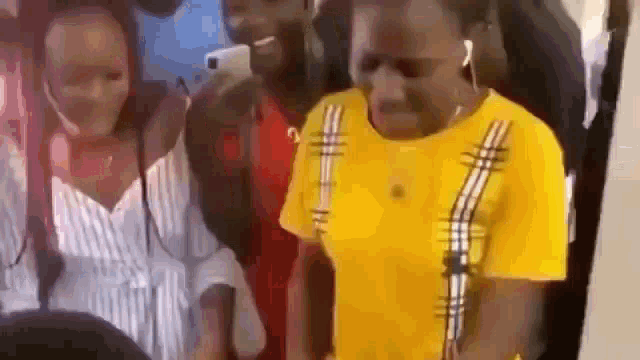 a group of people are standing next to each other on a plane . one of the people is wearing a yellow shirt .