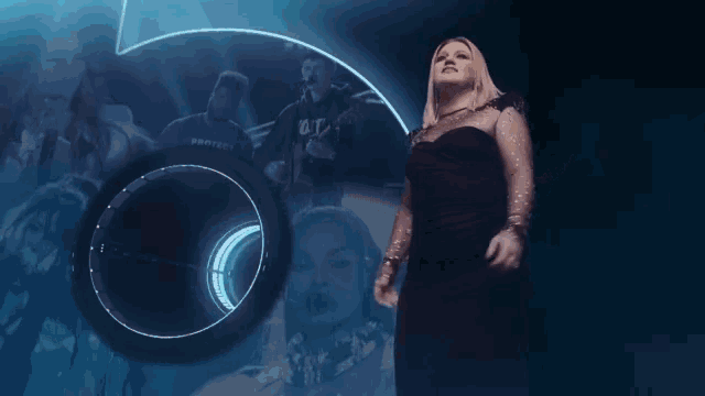 a woman in a black dress is singing in front of a number five