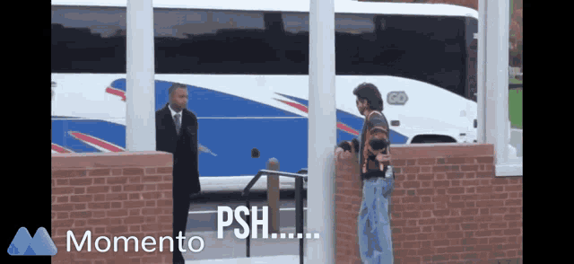 a man in a suit and tie stands next to a man in a striped sweater in front of a bus that says psh