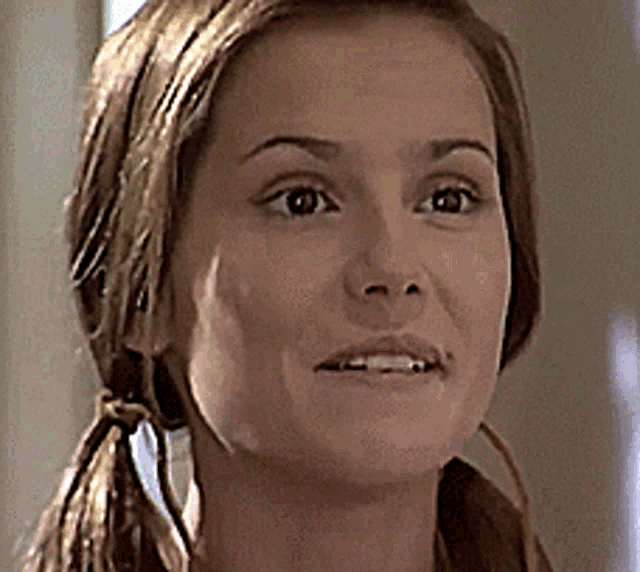 a close up of a woman 's face with pigtails