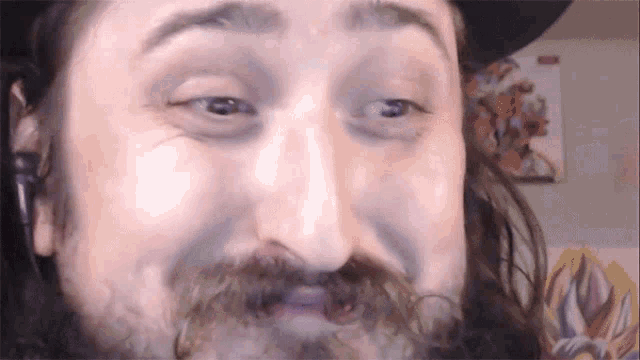 a close up of a man 's face with a hat on