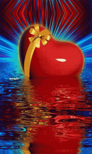 a red heart with a gold bow is floating in a body of water