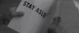 a person is holding a piece of paper that says buy do not question authority .