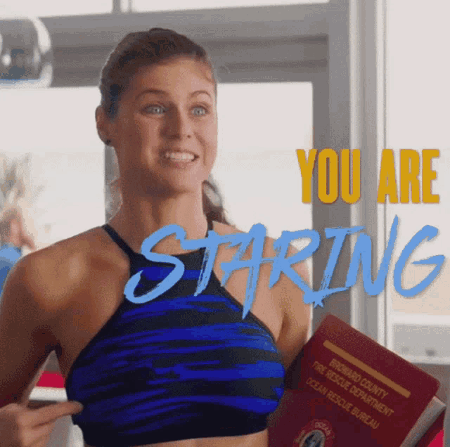 a woman holding a book that says ' you are staring ' on it
