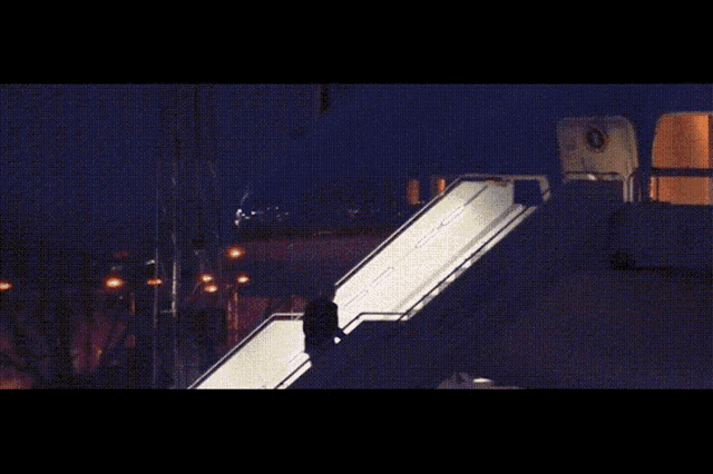 a man is walking up the stairs of an airplane