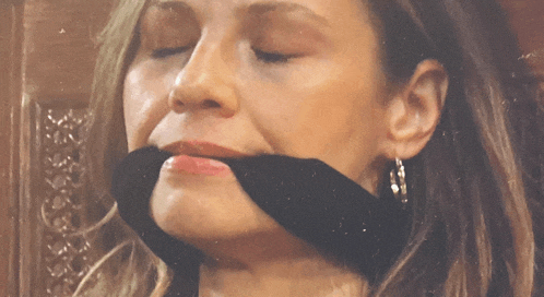 a woman with her mouth taped with a black ribbon