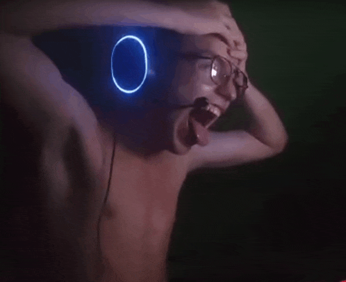 a man without a shirt is wearing headphones with a blue light on his head .