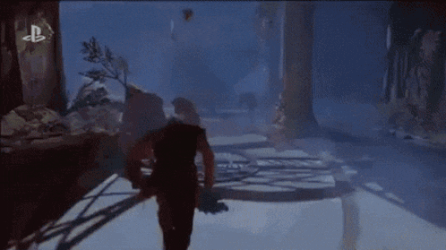 a person is playing a video game on a playstation 4 while standing in a snowy forest .