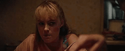 a woman with blonde hair is sitting at a table looking at the camera .