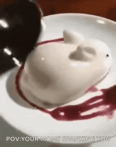 a close up of a white dessert on a plate with a cherry on top .