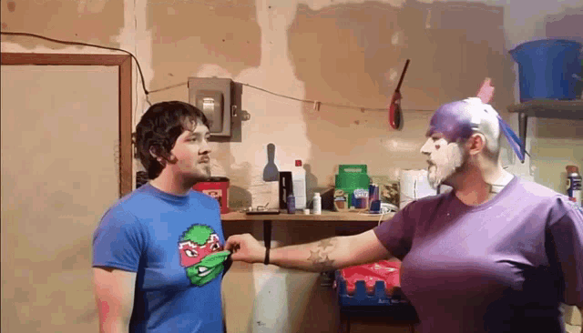 a man wearing a blue shirt with a ninja turtle on it