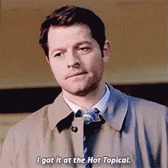 a man in a trench coat and tie is saying `` i got it at the hot topical . ''