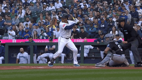 a baseball player swings his bat at a pitch in front of a banner that says america 's largest network