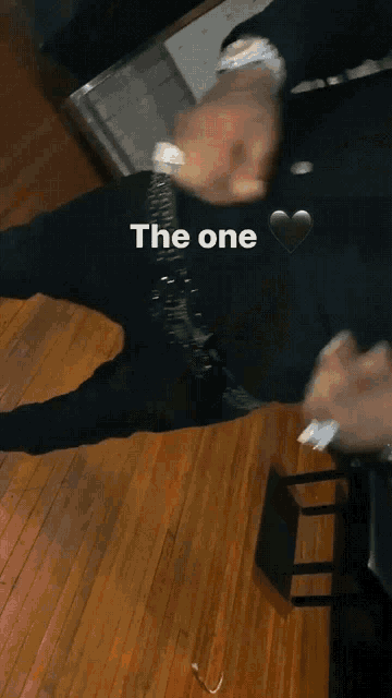 a man in a black shirt with a heart and the word " the one " on it