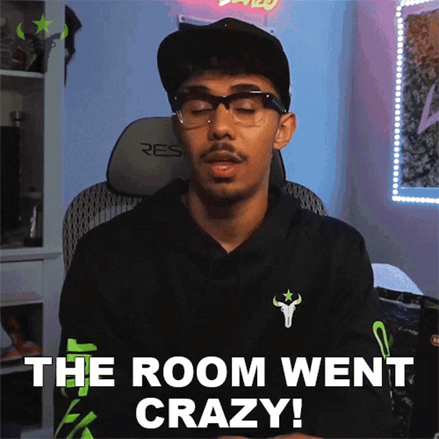 a man wearing glasses and a hat is saying " the room went crazy "