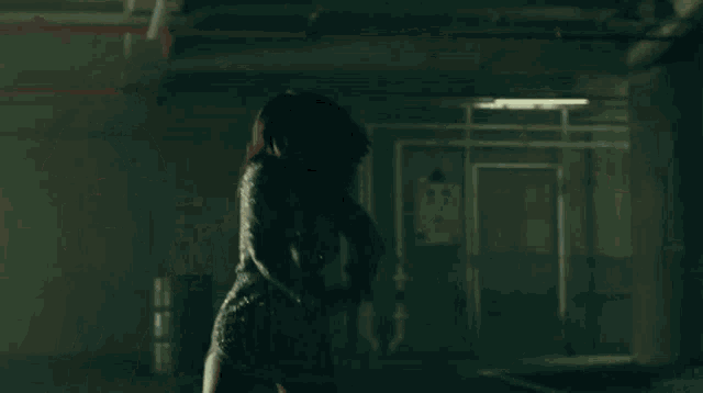 a woman is standing in a dark room with her hair blowing