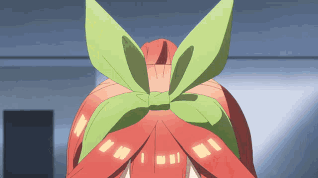 a close up of a person 's hair with a green leaf in it