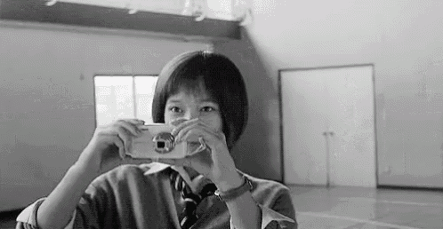 a girl is taking a picture of herself with a camera in a gym .