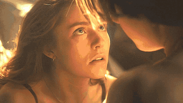 a close up of a woman 's face looking at a man 's face