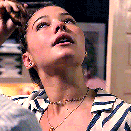 a woman wearing a striped shirt and a choker looks up at something