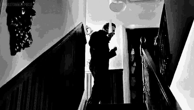 a man is walking down a set of stairs in a house .