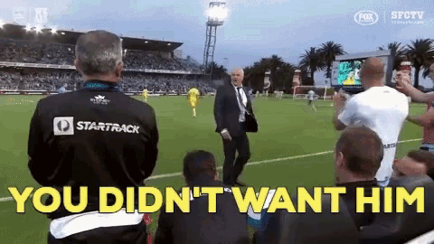 a man stands on a soccer field with the words you did n't want him behind him