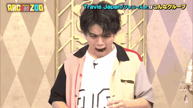 a man making a funny face with travis japan written on the bottom