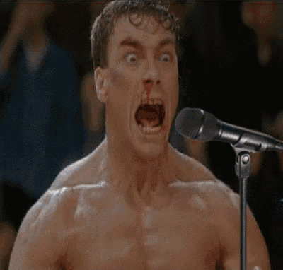 a man with blood on his nose is singing into a microphone