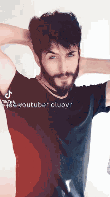 a man with a beard and blue eyes is wearing a black t-shirt and a choker