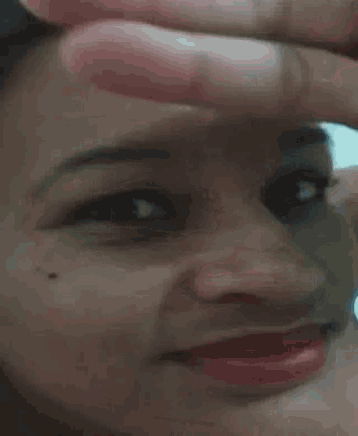a close up of a woman 's face with her hand on her forehead
