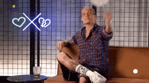 a man in a plaid shirt is sitting on a couch with his leg in a cast ..