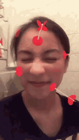 a woman with red hearts on her face and a butterfly on her head