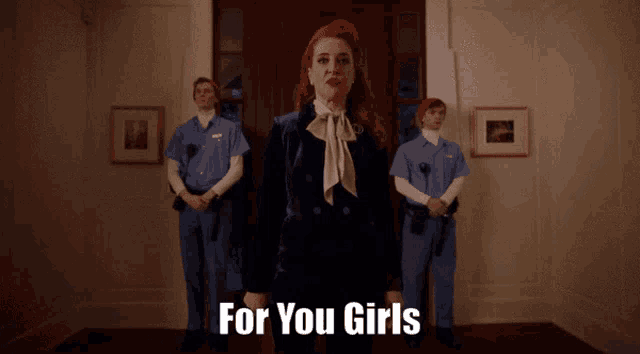 a woman with red hair stands in front of two guards with the words for you girls above her
