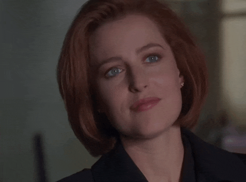 a woman with red hair is wearing a black jacket