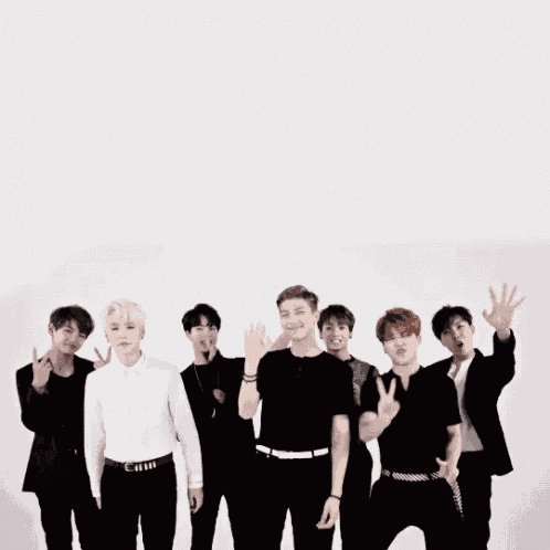 a group of young men are posing for a picture and one of them is wearing a white shirt