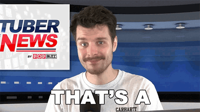 a man wearing a carhartt shirt stands in front of a tuber news sign