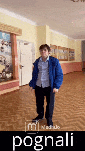 a man in a blue jacket is standing in a hallway with the word pognali written on the bottom