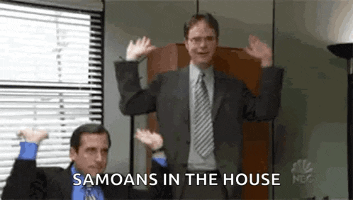 a man in a suit and tie is dancing in an office while another man looks on .