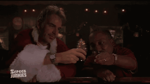 two men are sitting at a bar and one of them is wearing a santa suit