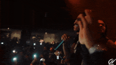 a man in a black shirt is dancing in front of a crowd .