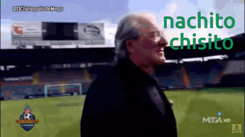a man stands in front of a soccer field with the words nachito chisito on the bottom