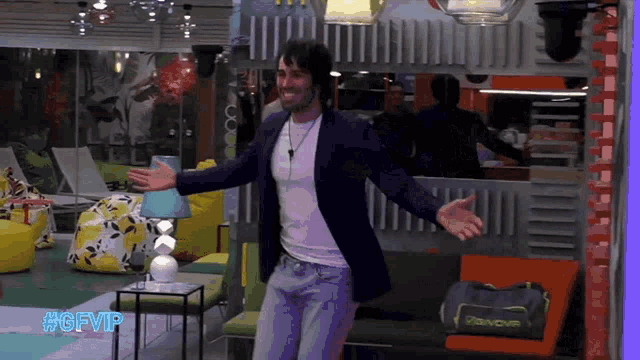 a man with his arms outstretched in a room with #gfvip written on the bottom