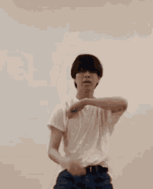 a man wearing sunglasses and a white t-shirt is dancing .